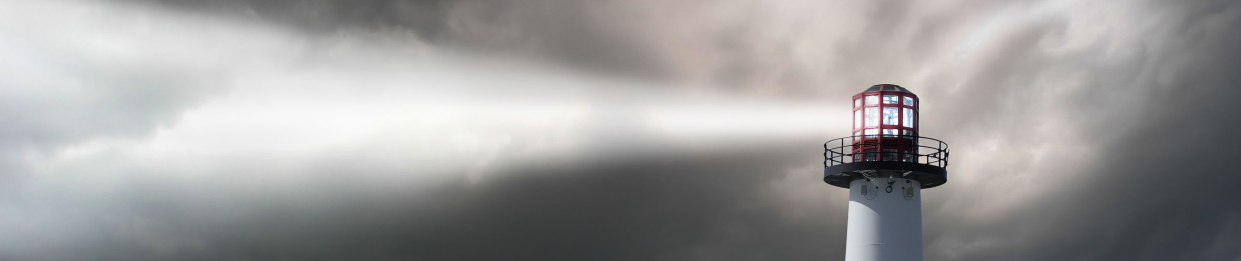 webagentur-mw-online-marketing - das Bild zeigt das Leuchtfeuer eines Leuchtturms vor einem wolkigen Sturmhimmel