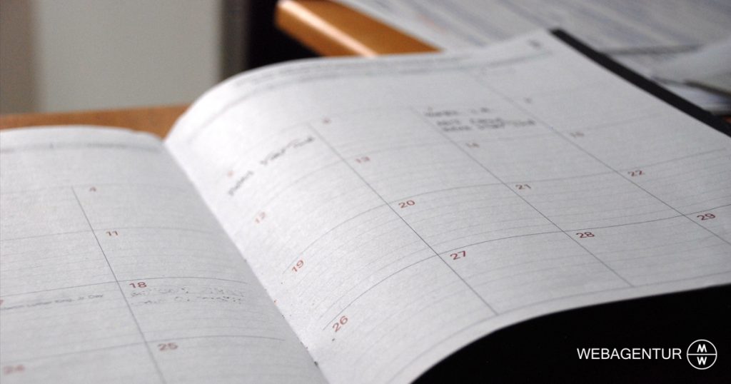 webagentur-mw-redaktionsplan-man sieht einen aufgeschlagenen Kalender auf einem Tisch liegen